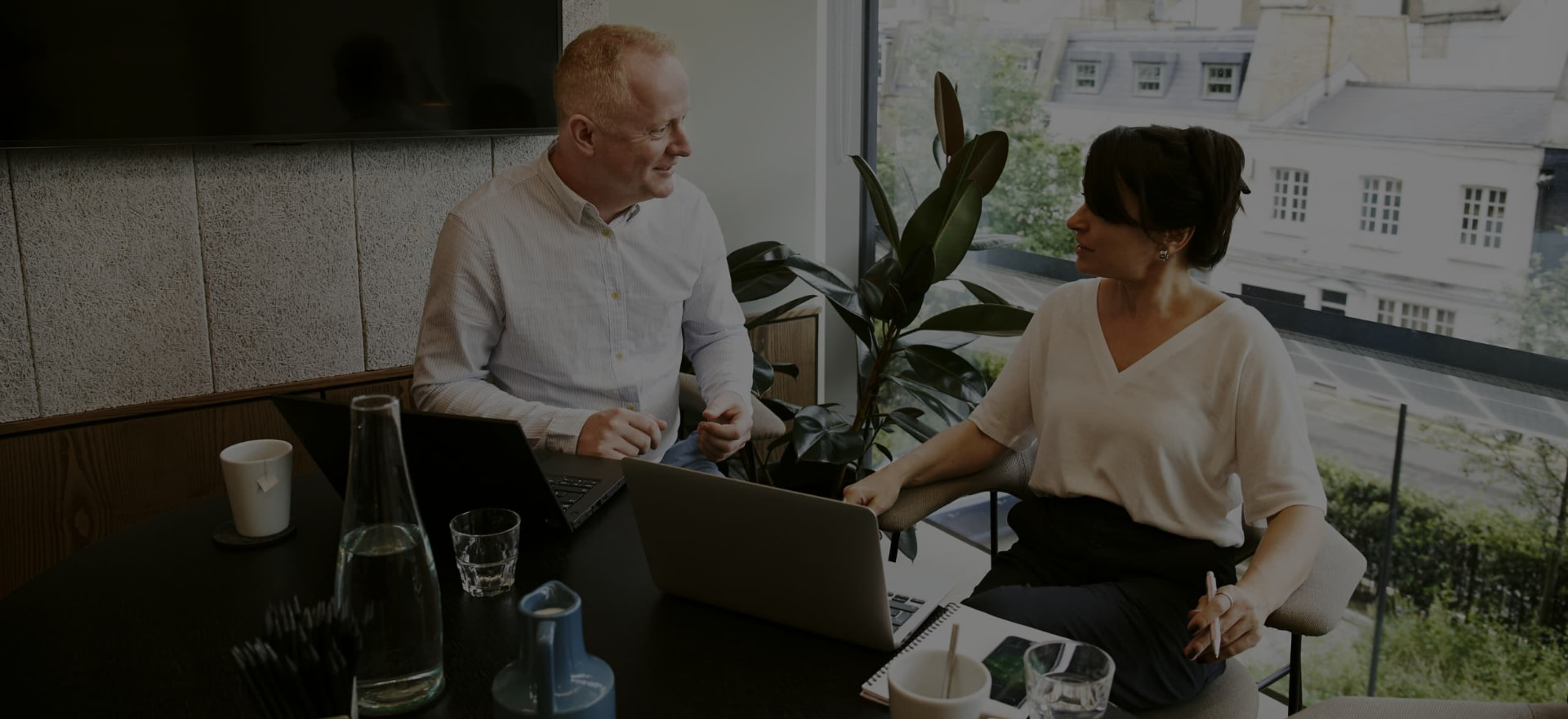 Consultants discussing AI strategy over a laptop